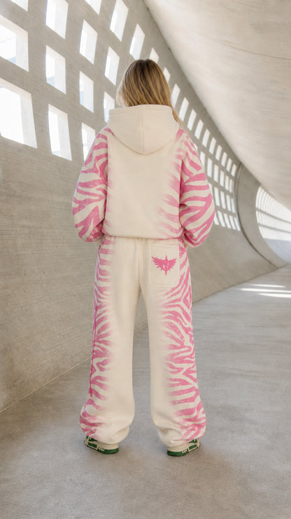 Back view of model wearing cream and pink two-piece oversized tracksuit set