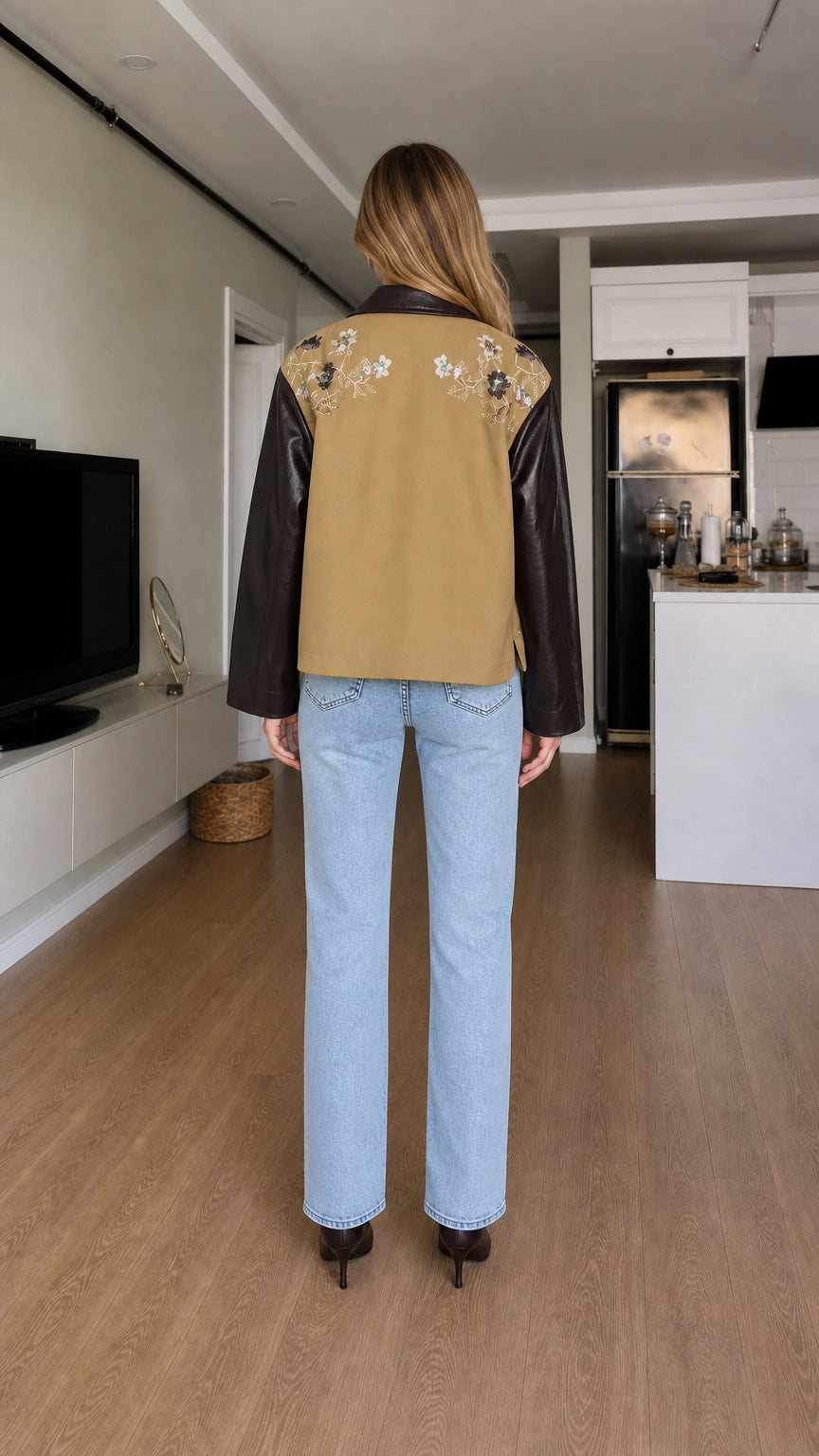 Back view of model showing embroidered yoke on camel and faux leather jacket