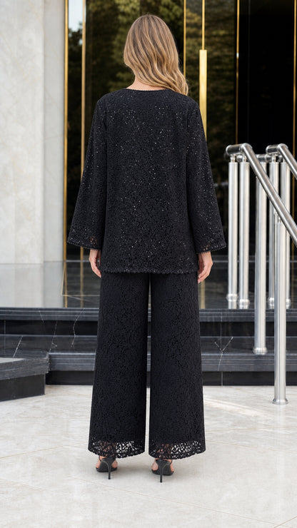 Back view of model wearing black sequined floral lace pant suit