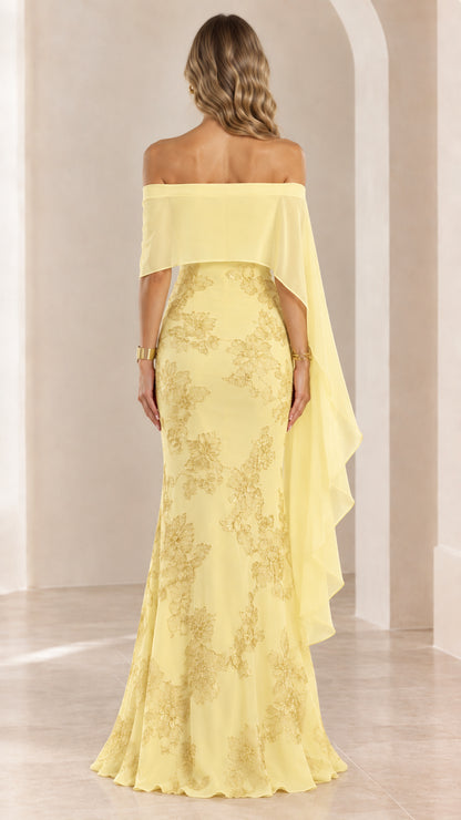 Back view of woman wearing yellow off-the-shoulder cape evening gown