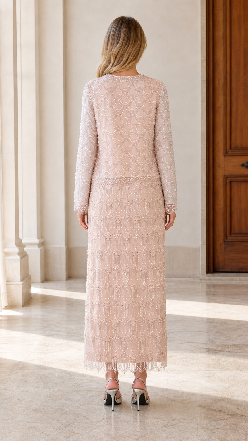 Back view of woman wearing blush pink beaded maxi formal dress