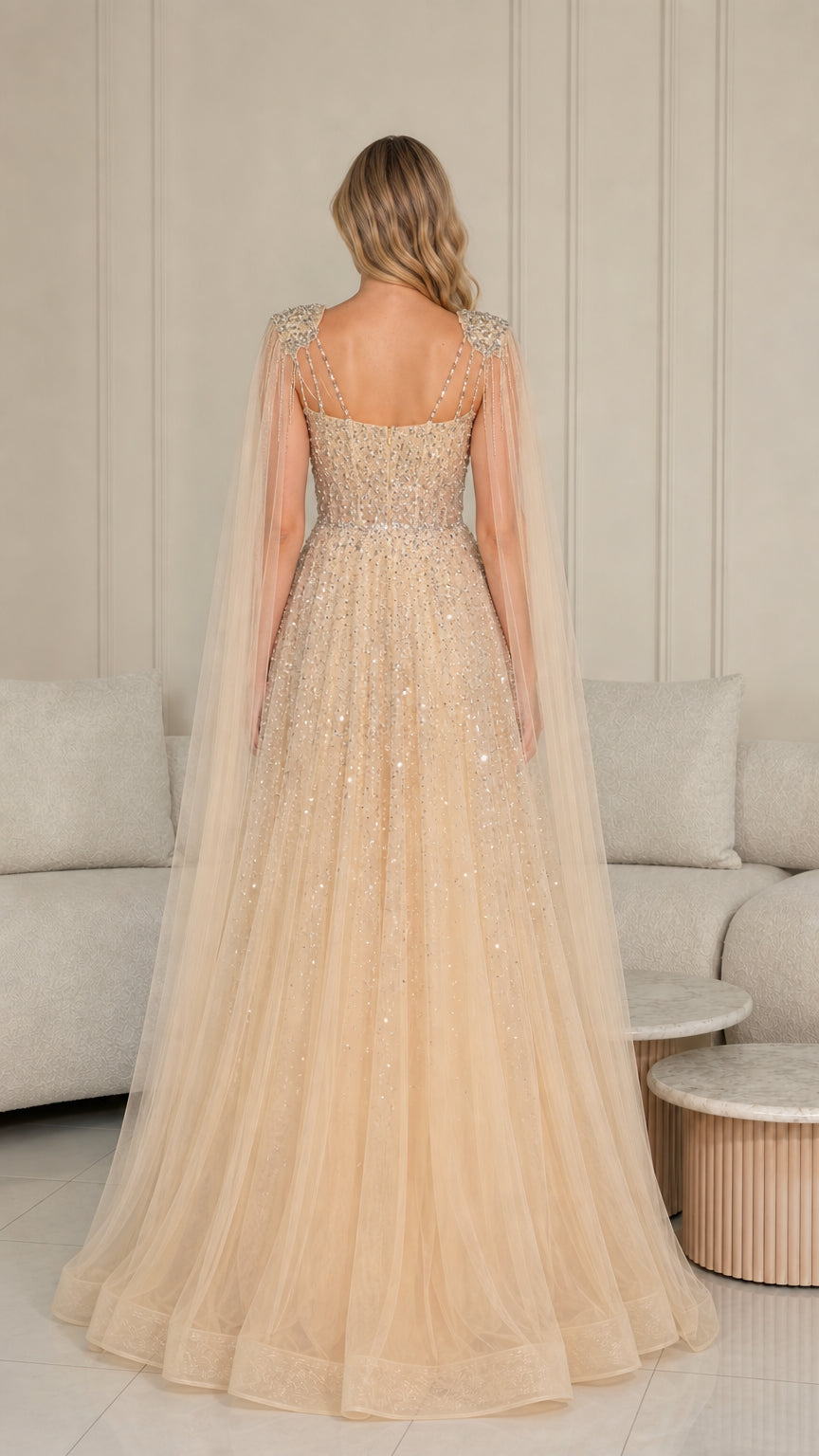 Back view of champagne floor-length evening gown showing flowing tulle cape