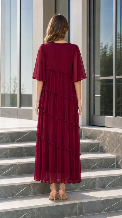 Back view of woman wearing elegant burgundy chiffon maxi dress with tiered ruffle details