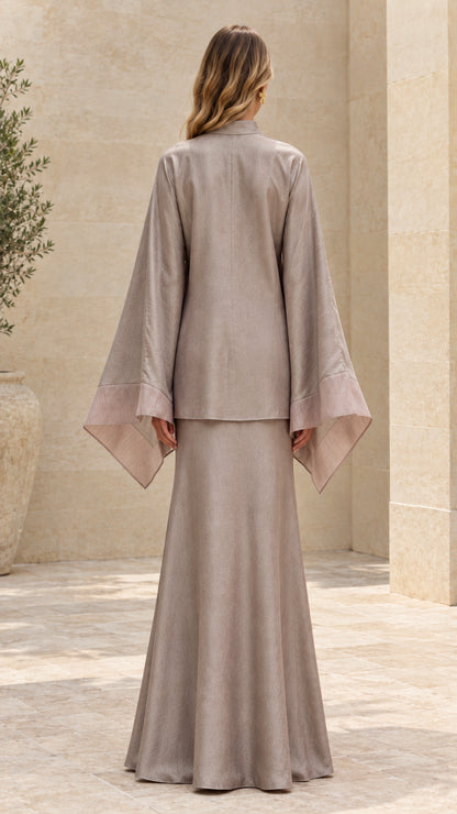 Back view of model in taupe long sleeve tunic and flowing maxi skirt set
