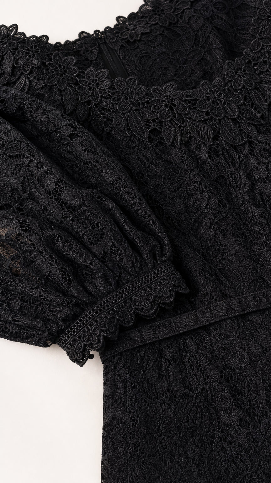 Close up of delicate black floral lace fabric and scalloped cuffs