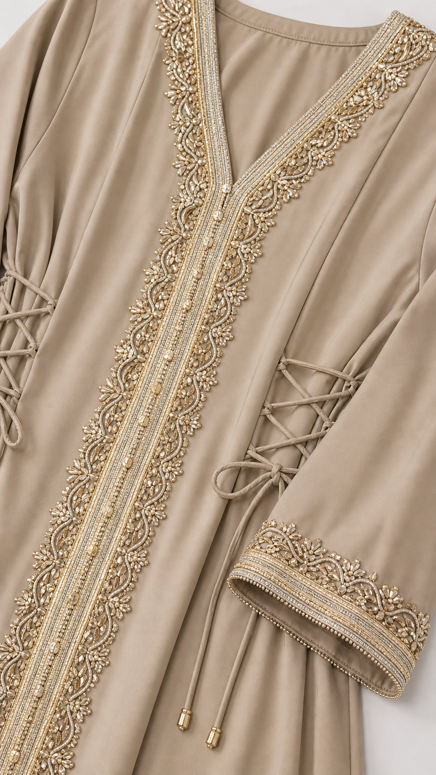 Close-up of gold metallic neckline embroidery and side lace-up ties