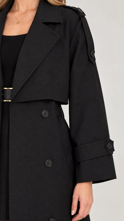 Close-up detail of wide lapel and shoulder tabs on black trench coat