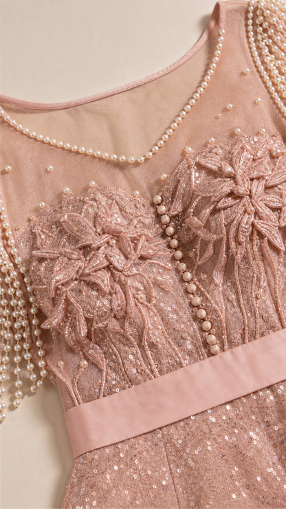 Close up of blush pink illusion bodice with pearl neckline, 3D floral lace, and pearl tassel sleeves