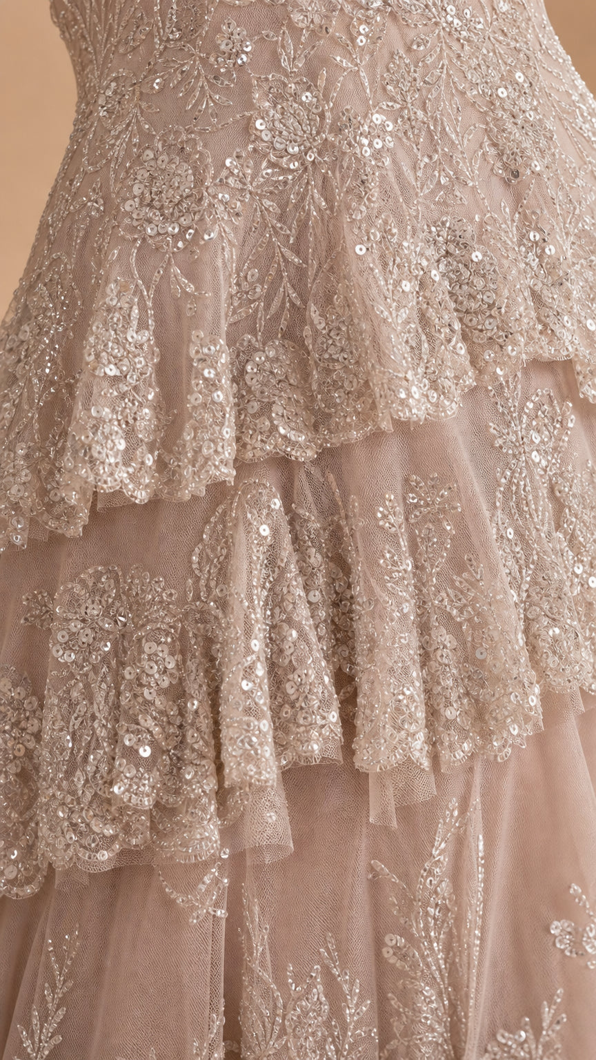 Close-up detail of champagne tiered ruffles with shimmering sequin embroidery