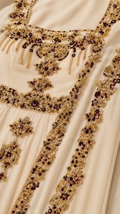 Close-up detail of metallic embroidery, beads, and gems on evening gown