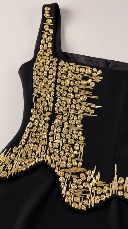 Close-up detail of ornate gold bugle beading on black dress bodice