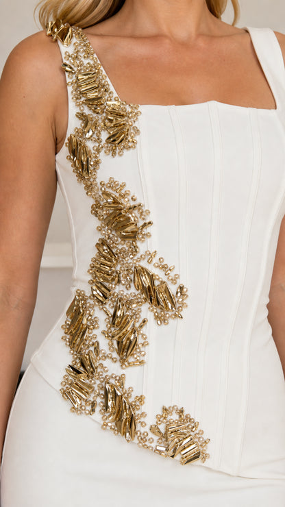 Close-up detail of golden beaded and sequined floral embellishment on white corset bodice
