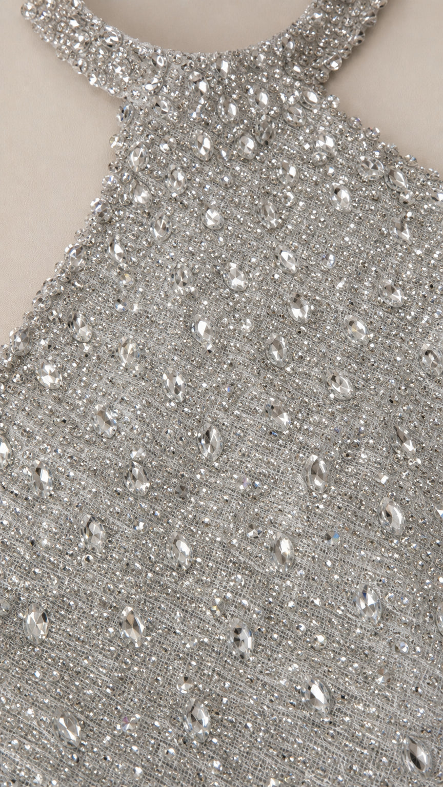 Close up view of silver fabric with shimmering sequins and crystal rhinestones