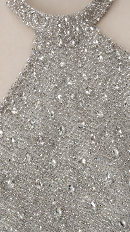 Close up view of silver fabric with shimmering sequins and crystal rhinestones