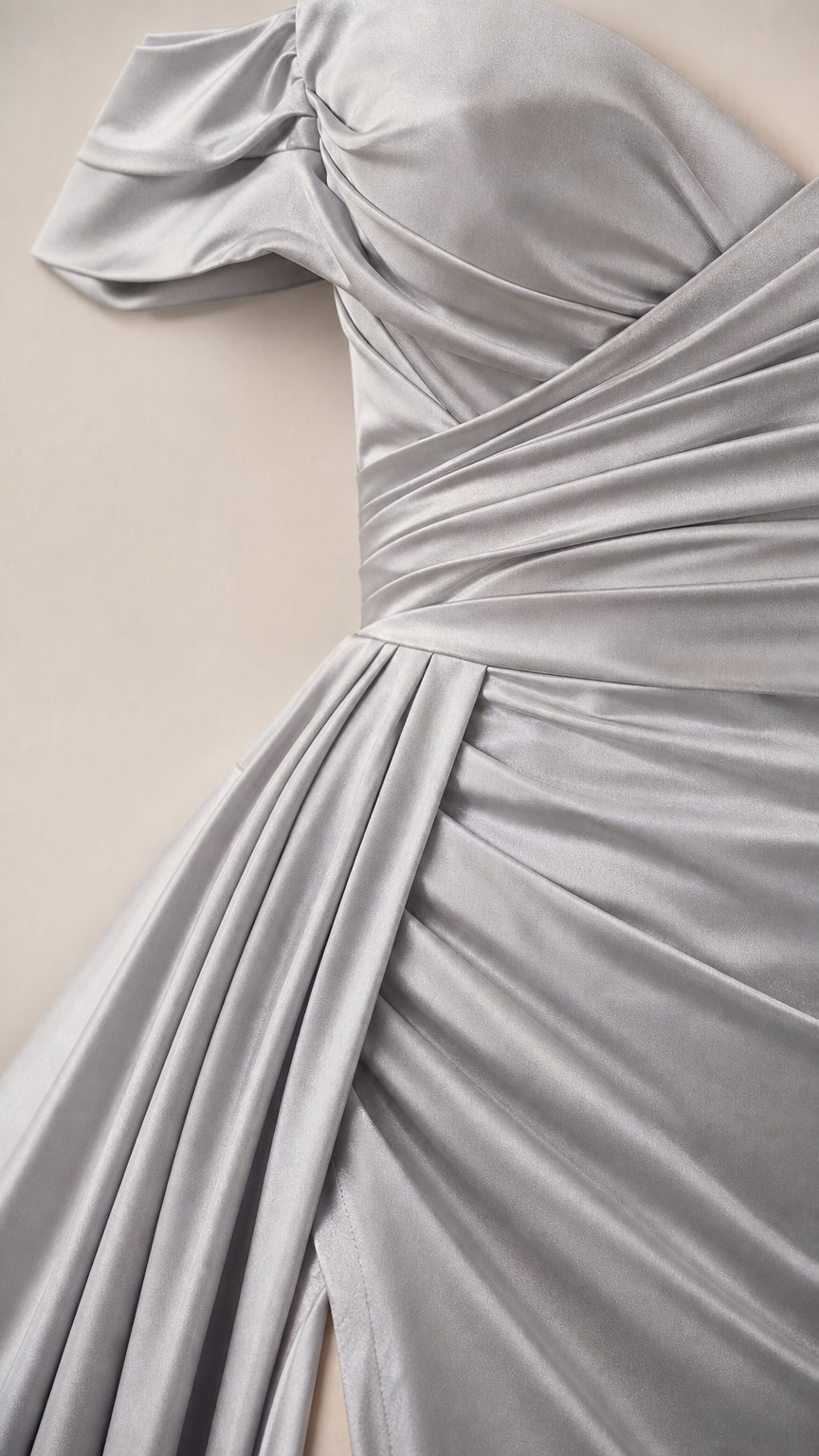 Close-up detail of silver satin fabric draping and diagonal waist ruching