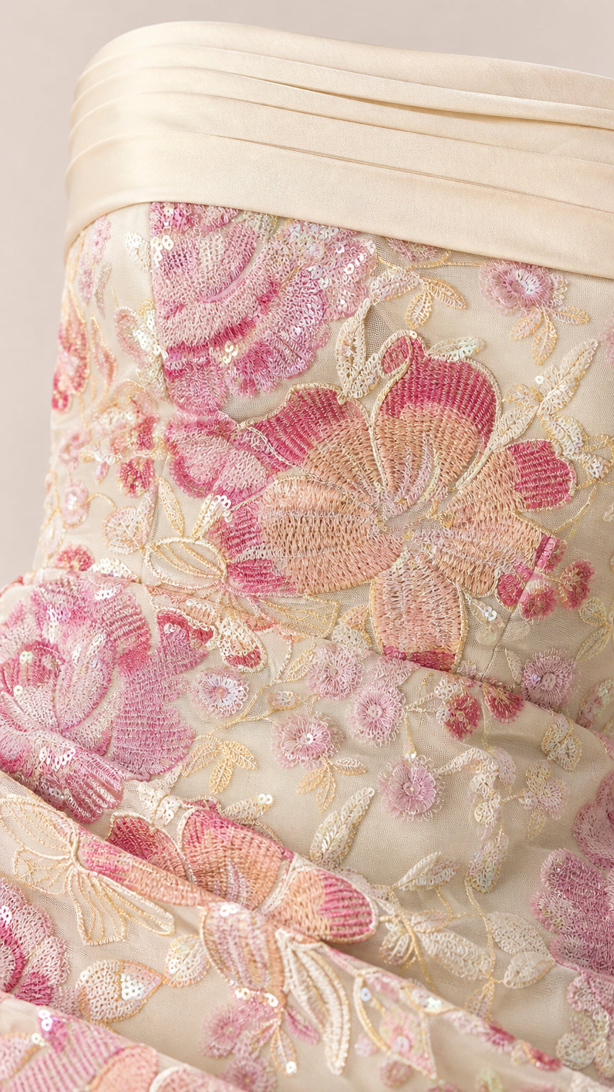 Close-up detail of floral embroidery and pleated bust trim on formal gown