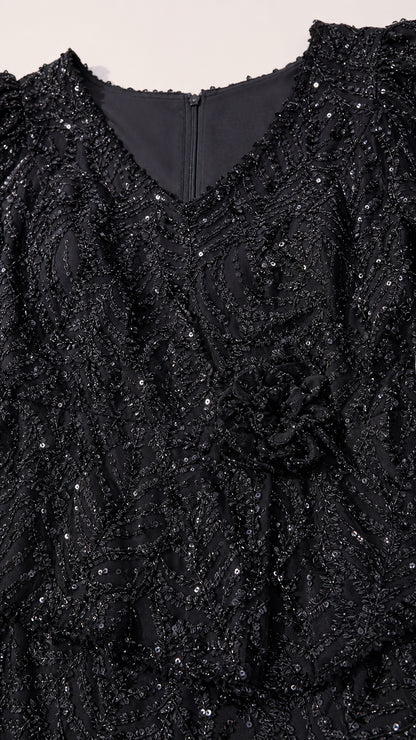 Close-up texture of black floral sequin embroidery and peplum detail