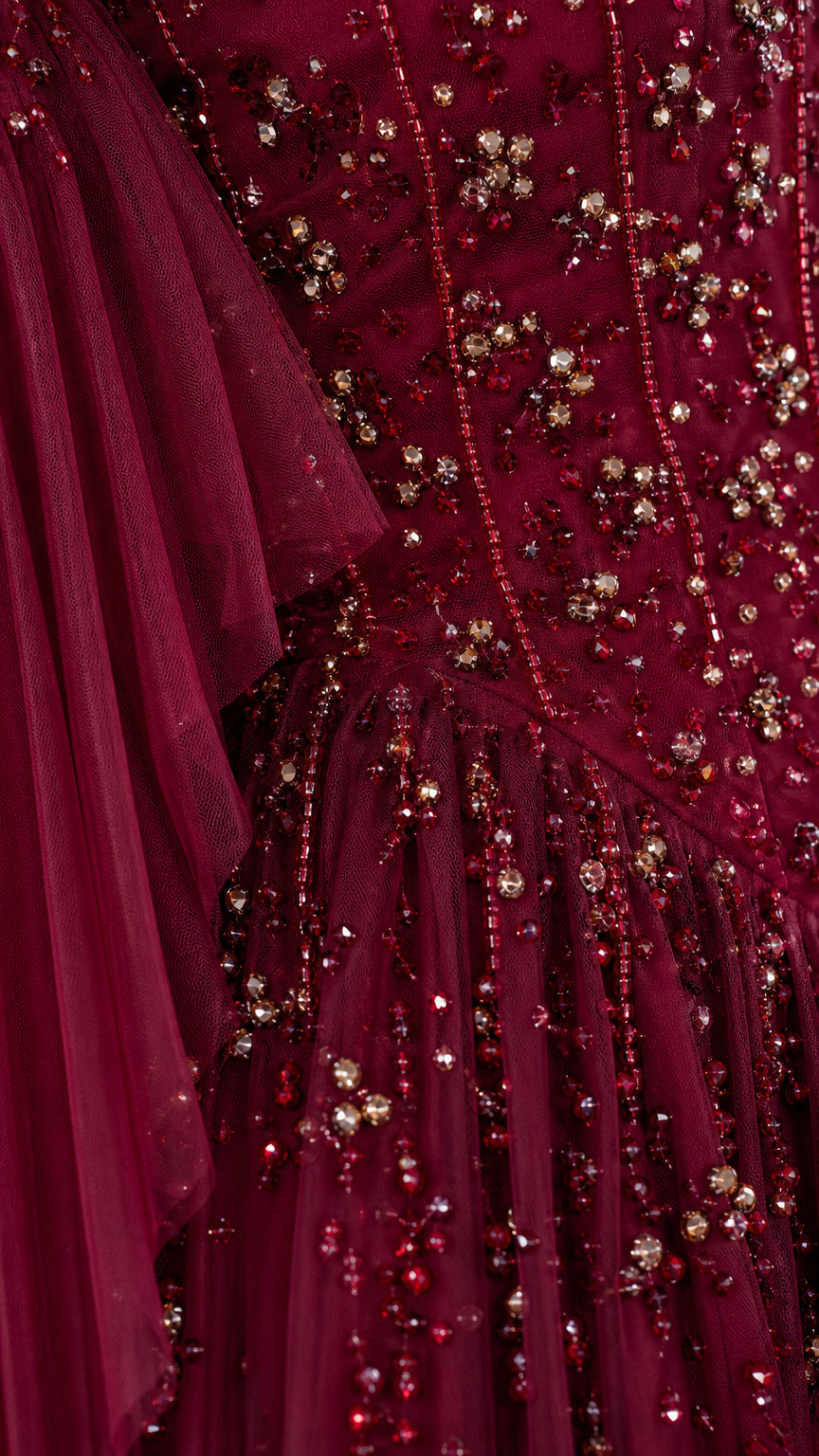 Close-up detail of intricate sequin and bead embellishments on burgundy tulle gown
