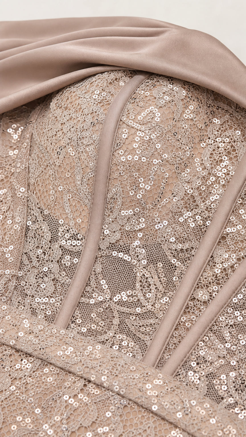 Close-up detail of sequined floral lace texture, corset boning, and satin trim