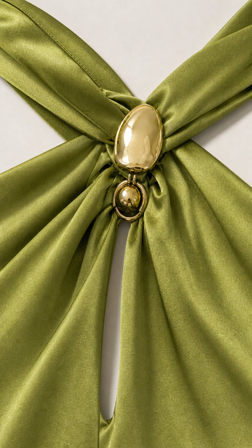 Close up detail of gold metallic oval brooch and halter keyhole neckline