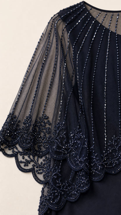 Close-up detail of sheer mesh capelet with sparkling beading and scalloped hem