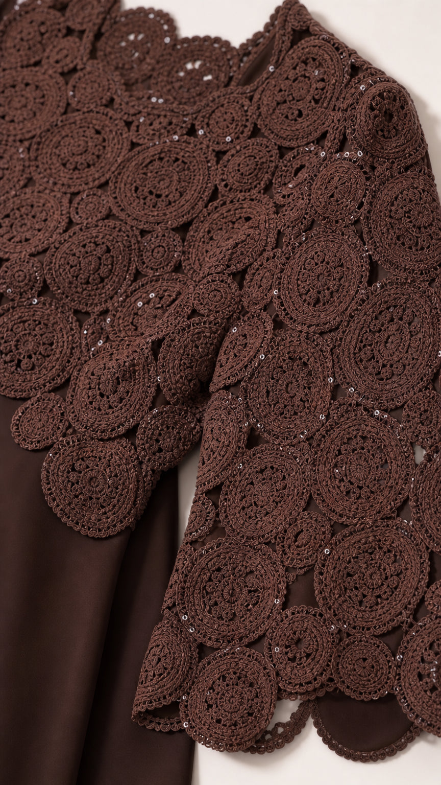 Close-up detail of chocolate brown floral crochet lace with scalloped edge and subtle sequins
