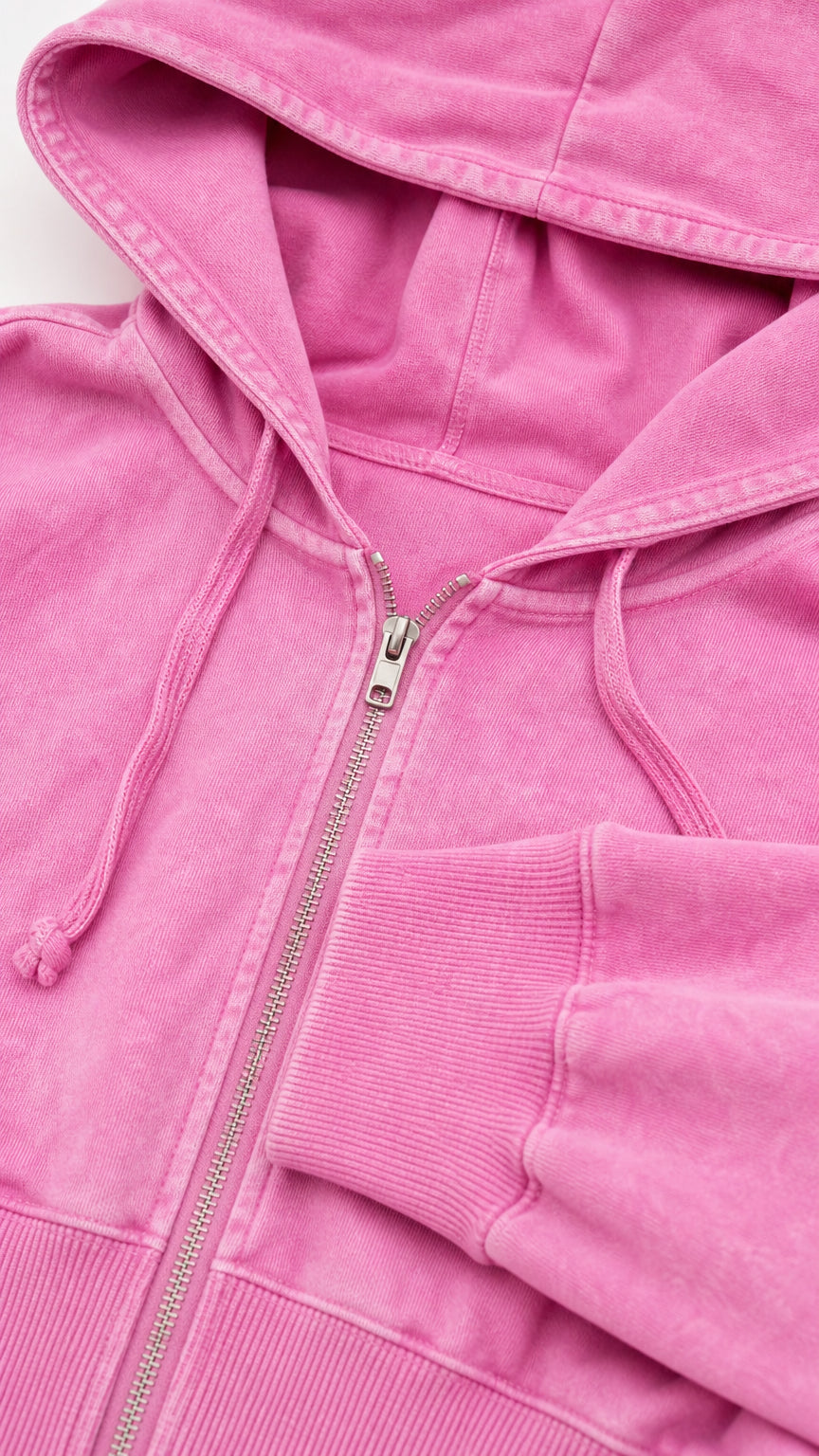 Close up detail of washed pink zip up hoodie showing drawstring hood and ribbed cuffs