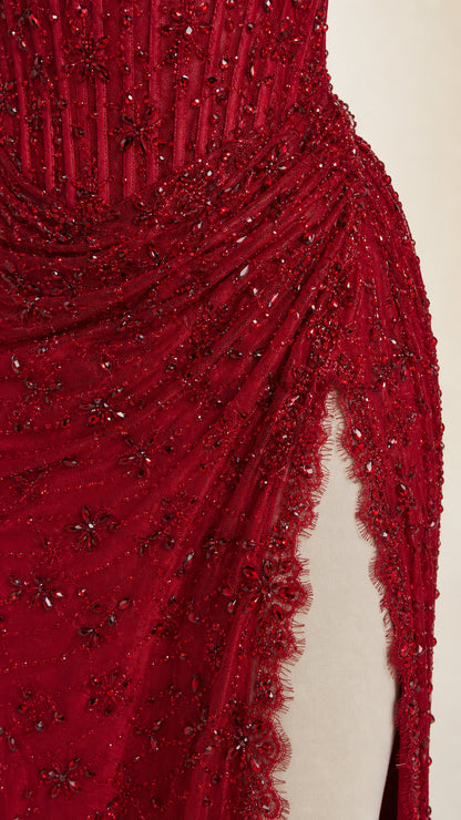 Close-up detail of red floral beading, sequins, and scalloped slit edge