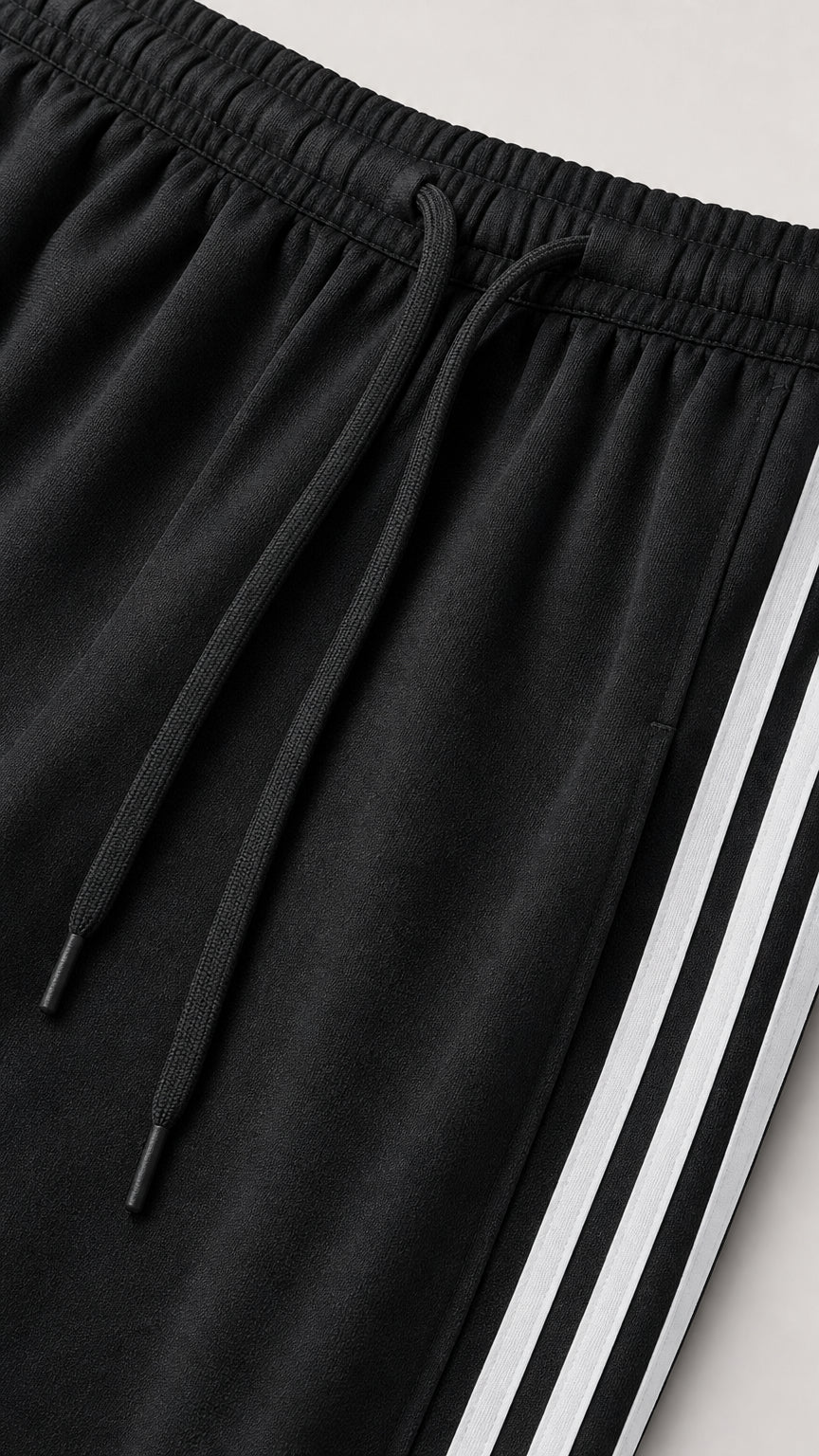 Close-up detail of black drawstring elastic waistband and side white stripes