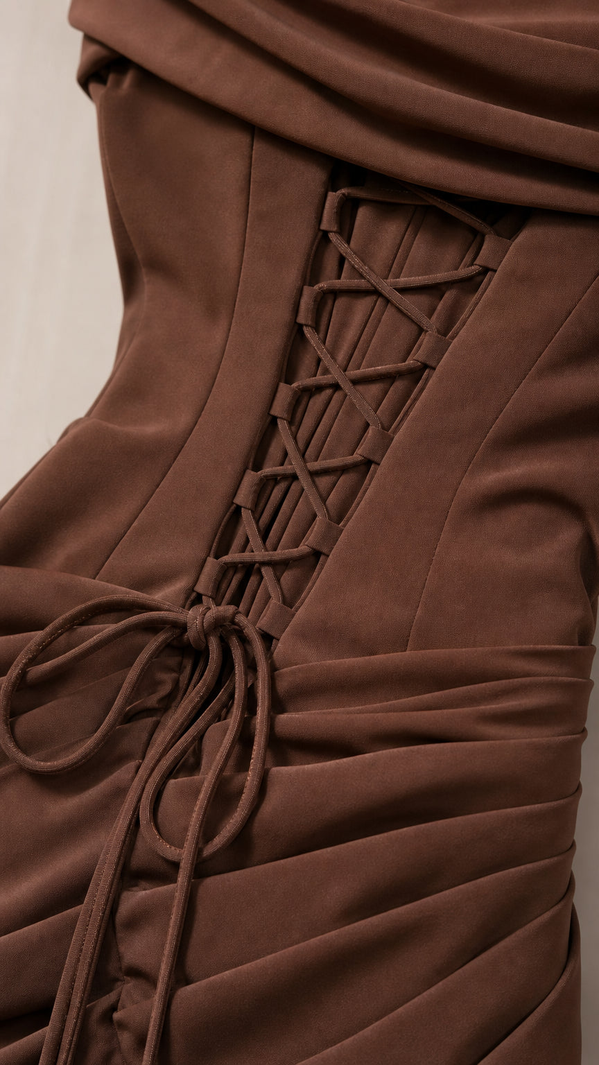 Close-up detail of back corset lace-up and ruching on brown formal dress