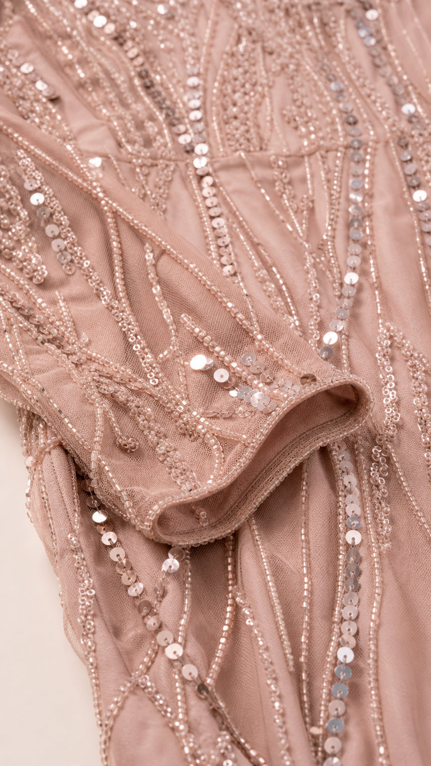 Close-up detail of dusty rose mesh sleeve showing intricate sequin and bead embellishments