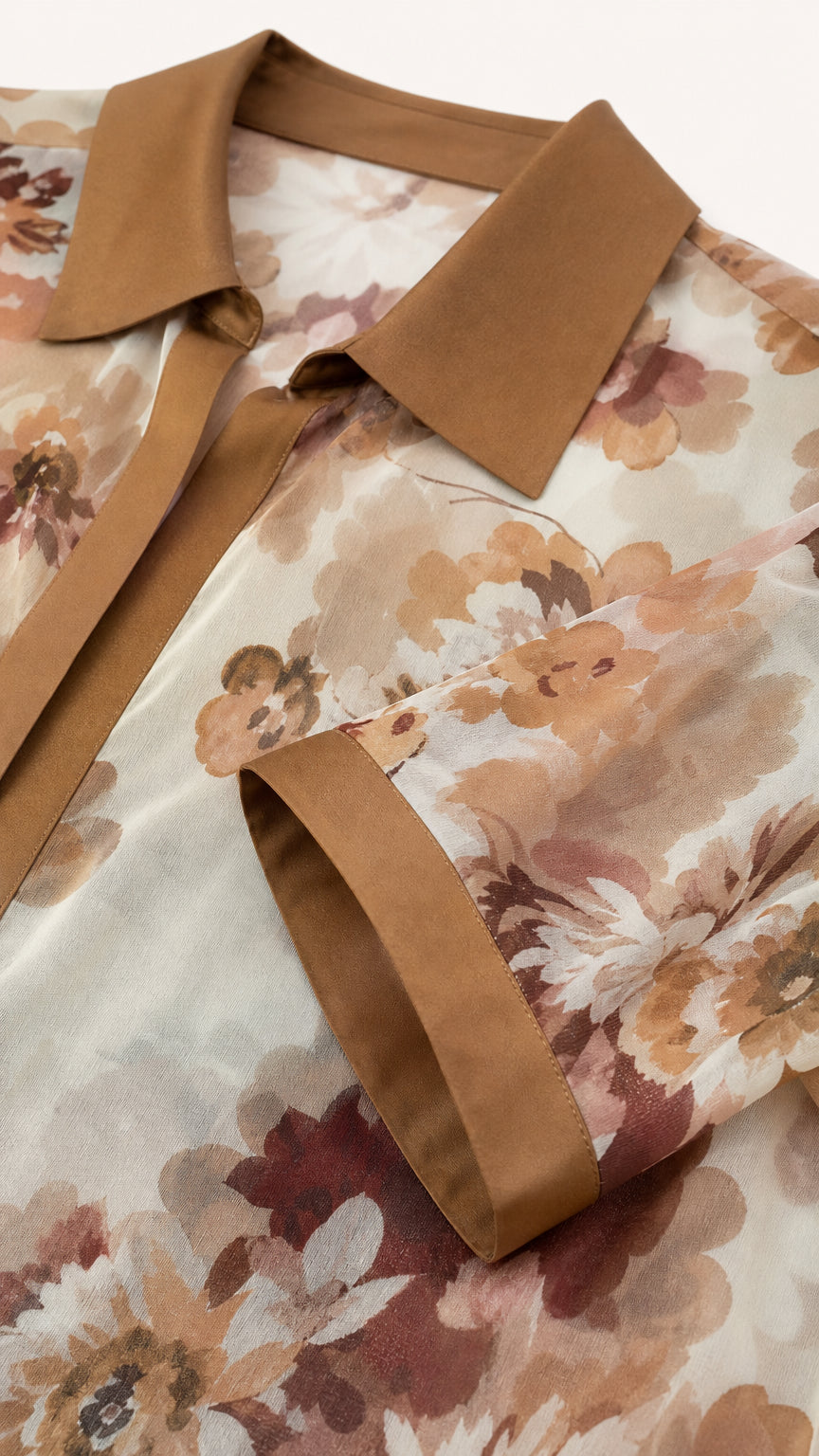 Close-up detail of floral print chiffon shirt showing solid collar and cuff design