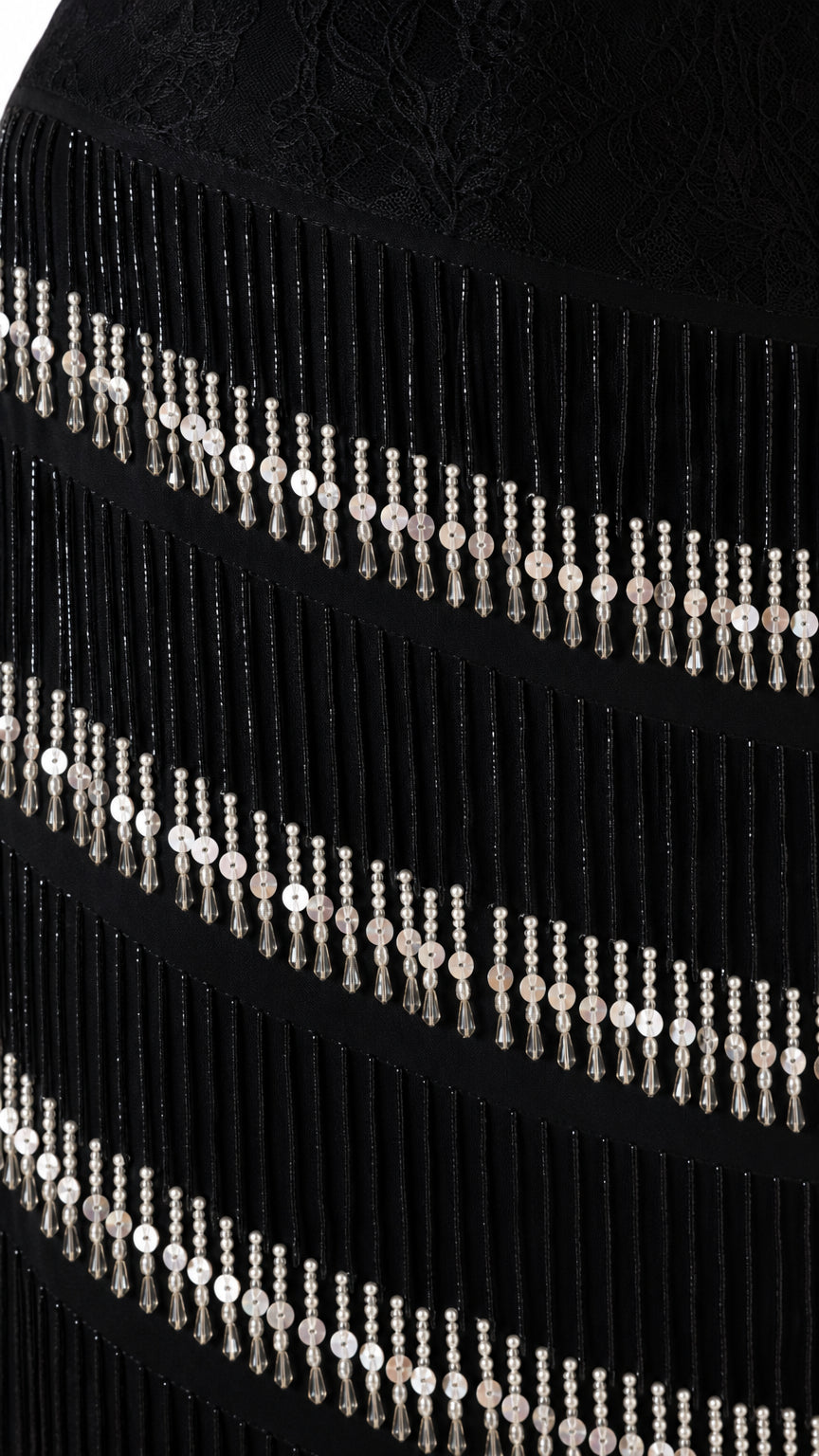 Close-up detail of lace texture and tiered beaded fringe strands