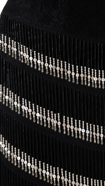 Close-up detail of lace texture and tiered beaded fringe strands