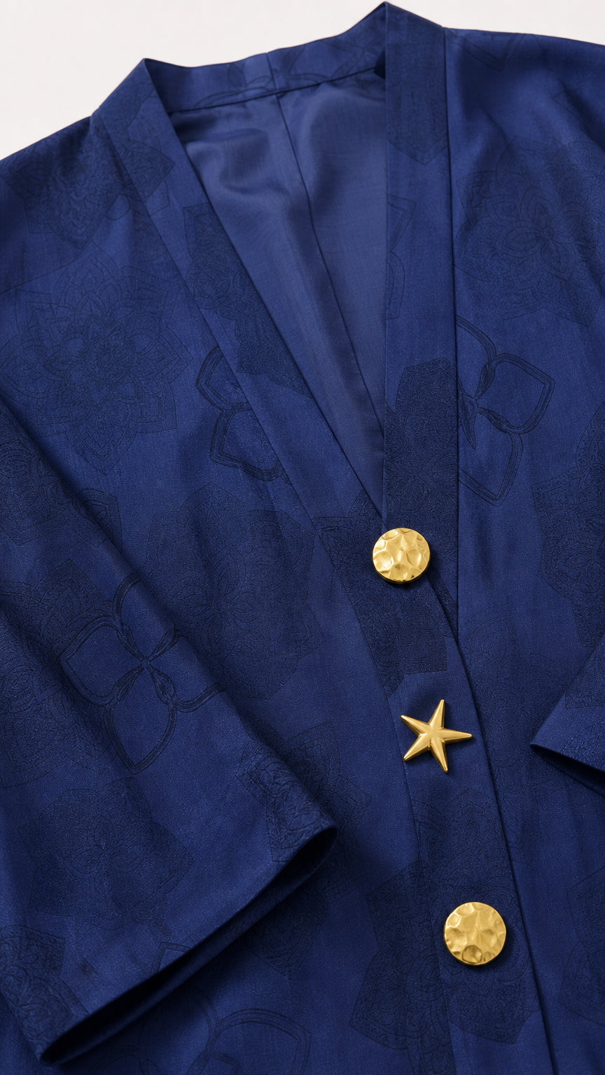 Close-up detail of navy jacquard fabric and decorative gold star and disc buttons