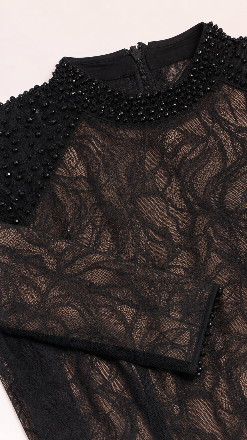 Close up view of black lace fabric and beaded mock neckline detail