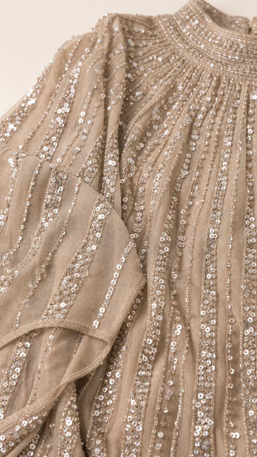 Close-up detail of champagne pleated mesh fabric with linear sequin stripes