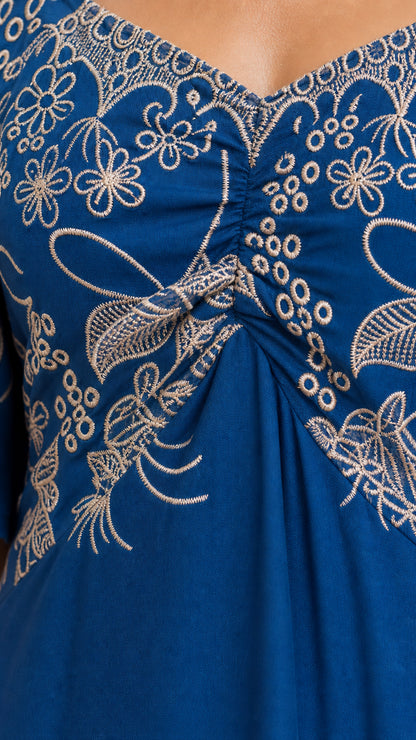 Close-up detail of sweetheart neckline and floral embroidery on blue fabric
