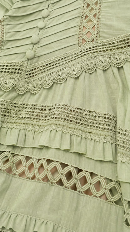 Close-up detail of Sage Green dress showing pleated bodice, decorative buttons, and crochet lace trims