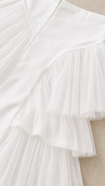 Close-up detail of white smooth woven fabric and pleated tulle ruffle layers
