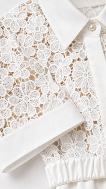 Close-up detail of floral lace texture, pointed collar, and pearlescent button