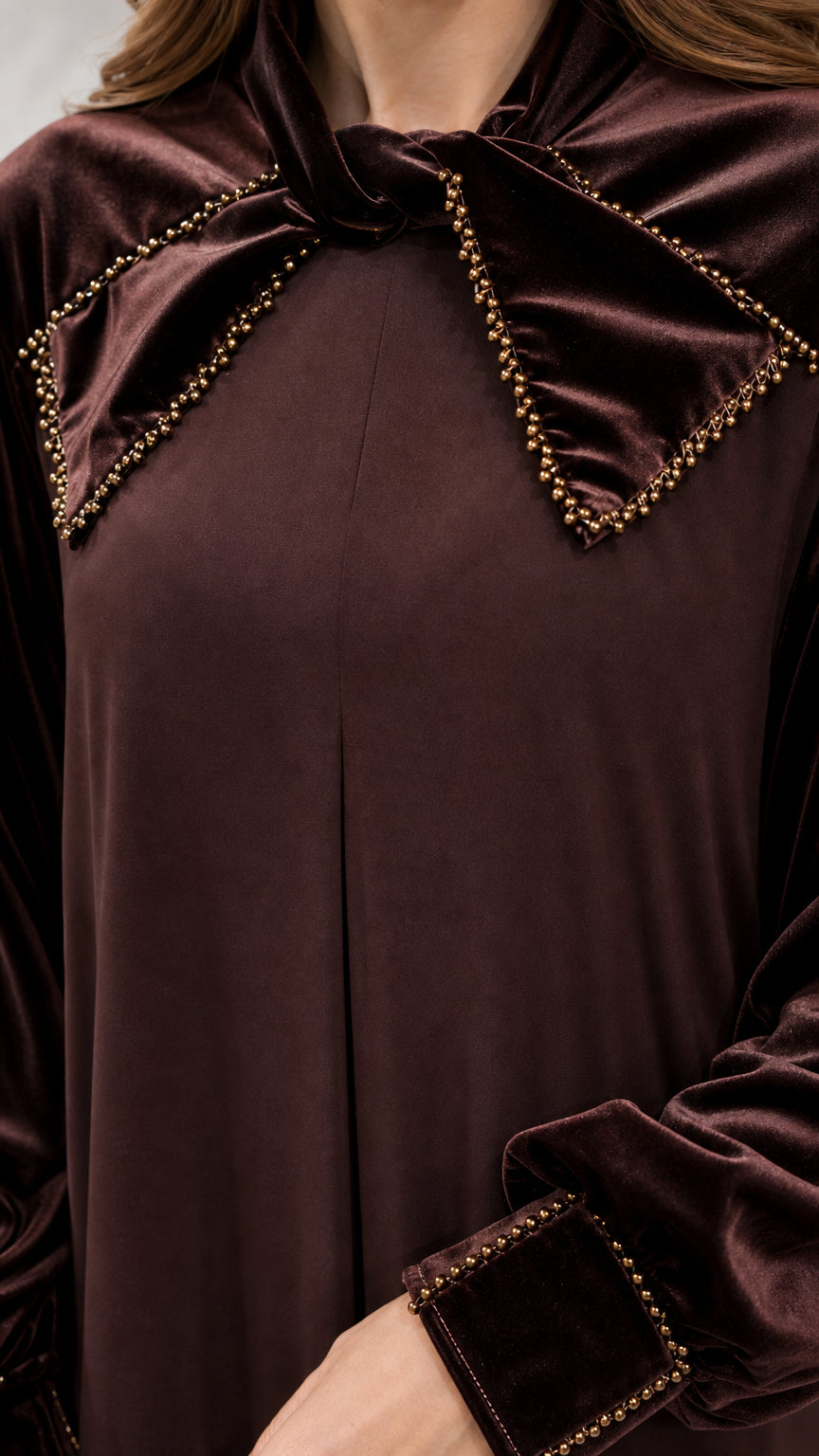 Close-up of beaded bow collar and cuff detail on brown velvet dress