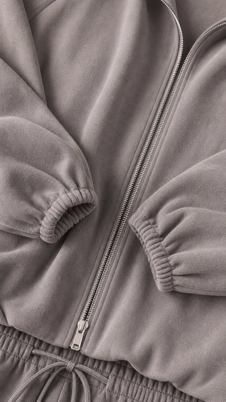 Close-up detail of grey soft fleece fabric, sturdy zipper, and gathered elastic cuffs