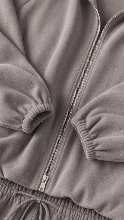 Close-up detail of grey soft fleece fabric, sturdy zipper, and gathered elastic cuffs