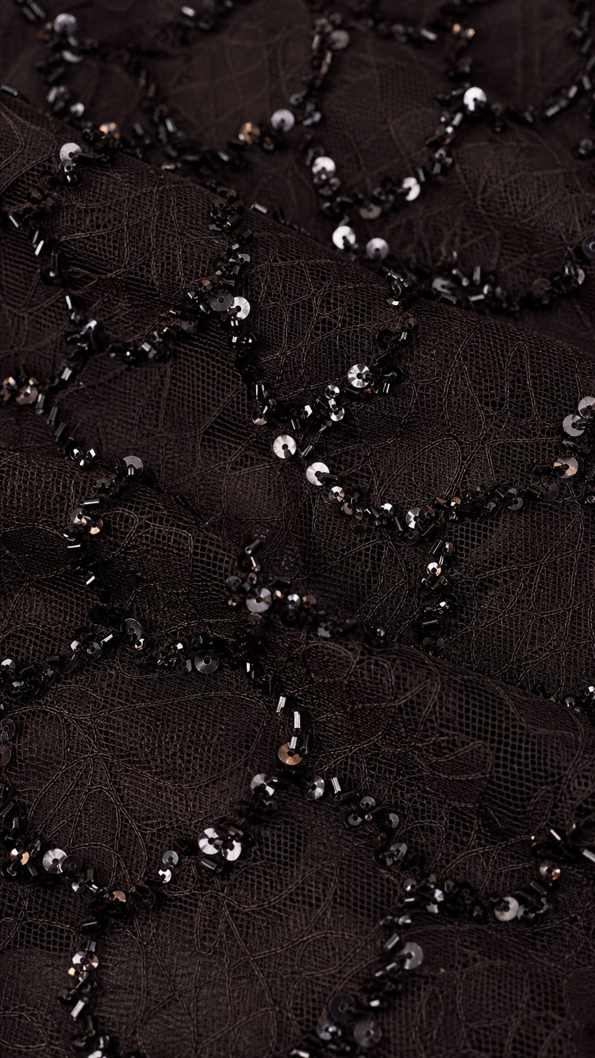 Close-up detail of black sequin embroidery on sheer mesh fabric