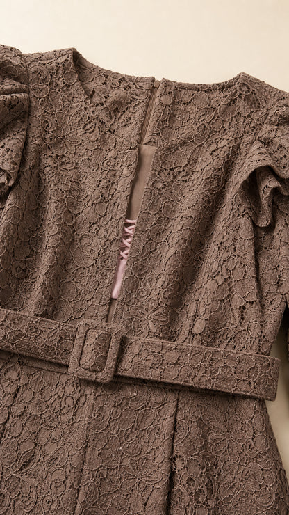 Close-up detail of mocha brown floral lace texture, neckline notch, and buckled belt