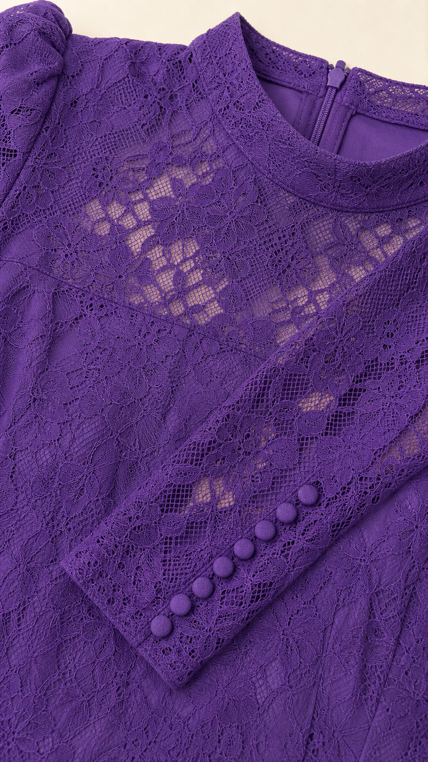 Close-up detail of purple floral lace, mock neckline, and buttoned sleeve cuffs