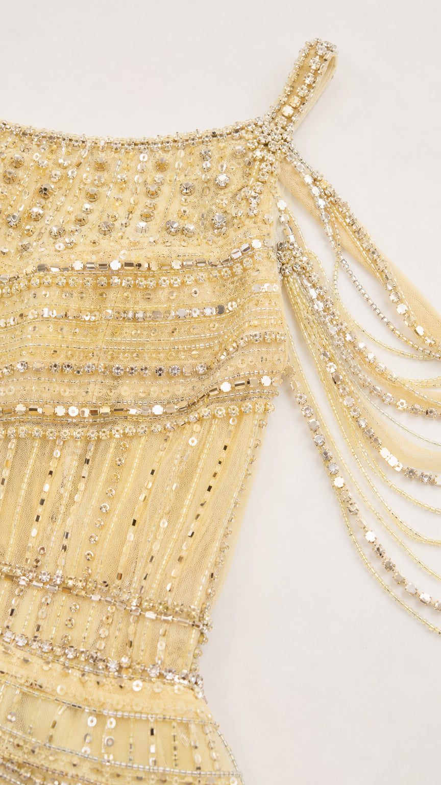 Close-up detail of intricate beadwork, sequins, and shoulder fringe on bodice