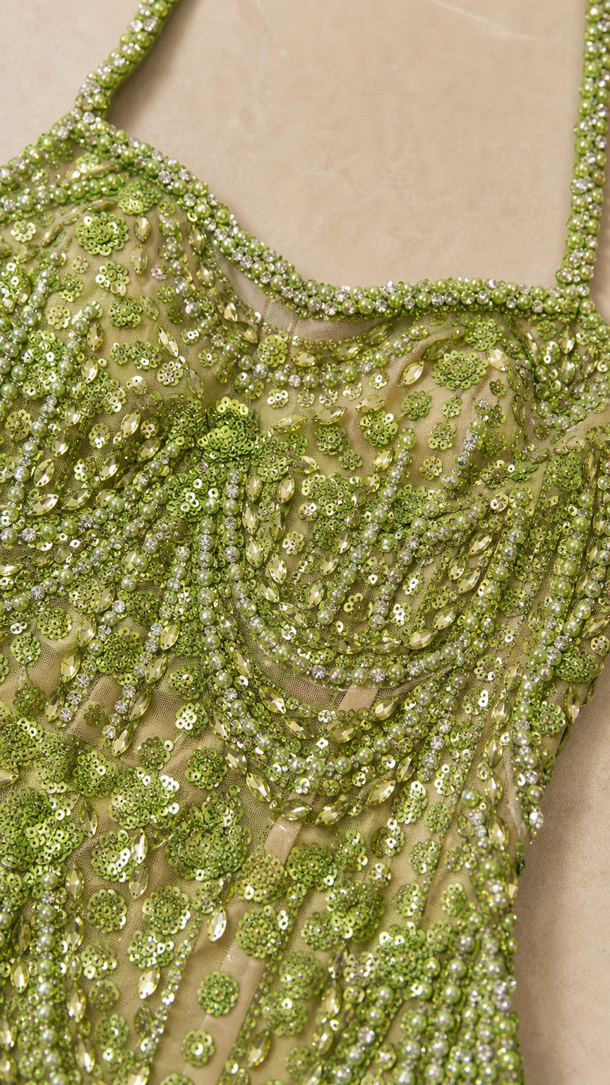 Close-up detail of green beaded scalloped embroidery and sequins