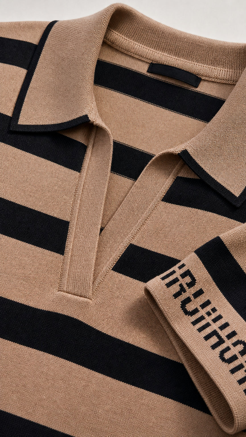 Close-up detail of the open polo collar and cuff text design on the Camel striped knit top